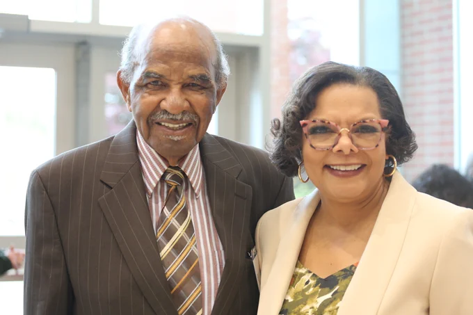 A man and woman in blazers pose for a picture. The man is Dr. Dudley Flood. The woman is the person of honor for the Friday Medal Ceremony, Dr. Maria Pitre-Martin.