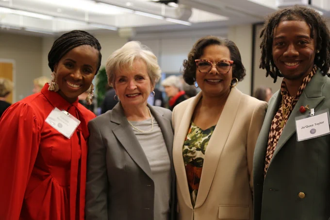 A group of people stand in a line smiling at the camera. Featured in the middle of the photo is Dr. June Atkinson and Dr. Maria Pitre-Martin.