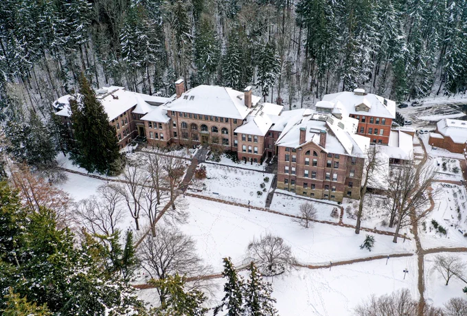 Drone view of Old Main and lawn covered in snow from 2023