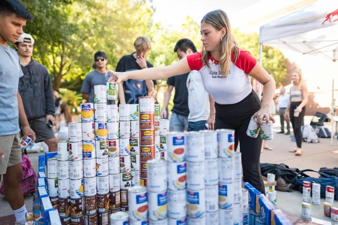 Chico State students stack canned goods for a food drive event.