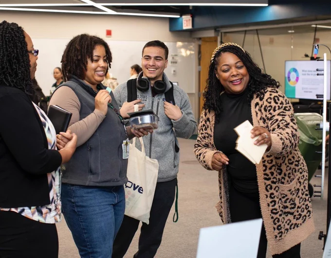 Four Rush University students laughing and interacting joyfully at the Fall Health Social event. 