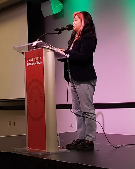 author Gina Chung at a red podium
