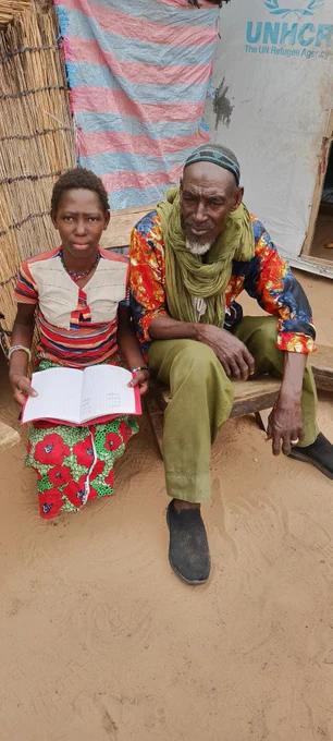 Fatoumata poses here with her grandfather in front of their hut, which serves as lodgings at the Wendou IDP site, in the courtyard of the University of Dori. (c)DIPAMA Yamba
