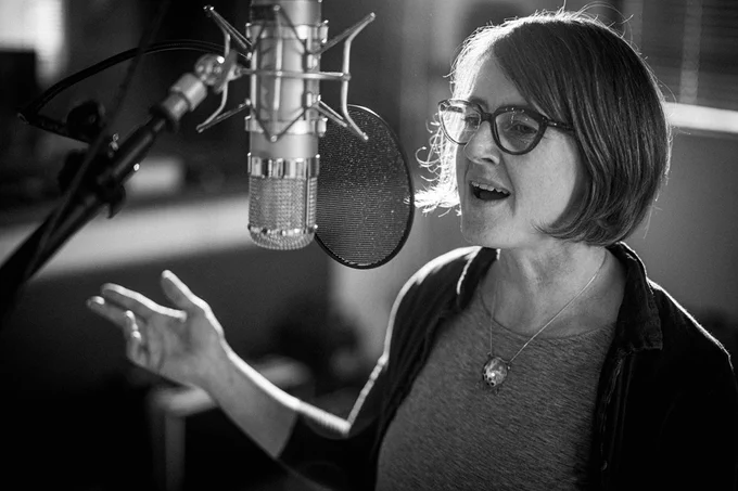 Black and white photo of Karine Polwart singing into a microphone. 