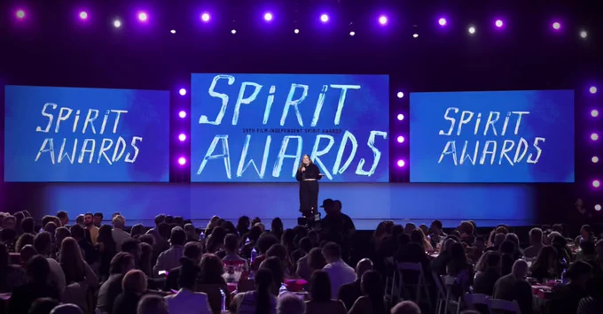An award stage with a host introducing the 2025 Spirit Awards and its nominees to the audience.