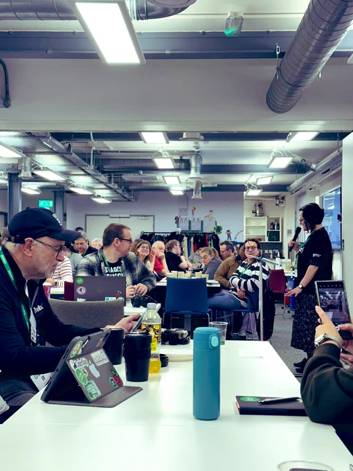 Zoe is giving a presentation to a room full of volunteers and mentors from coding clubs
