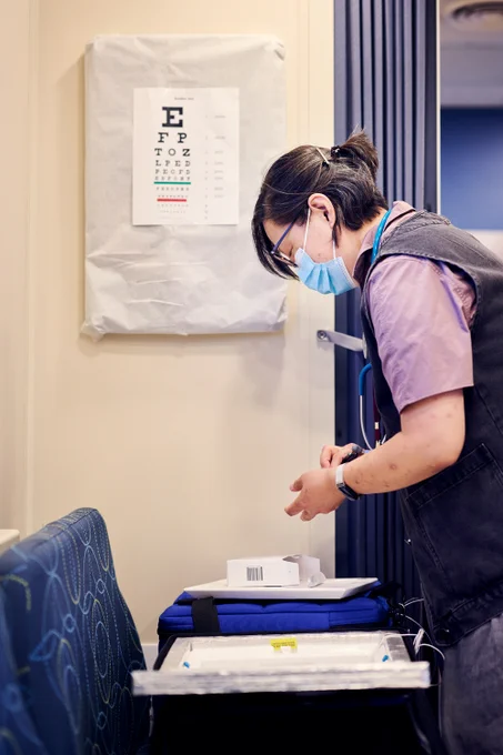 RFU member inside the Care Coach wears a mask and holds one of the medical supplies.