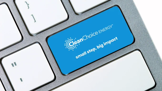 A close-up image of a computer keyboard with a blue key featuring the logo and slogan of CleanChoice Energy, reading "small step, big impact.