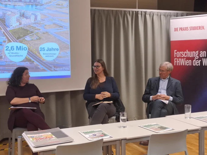 eine Gruppe von Menschen sitzt vor einer Projektionswand.