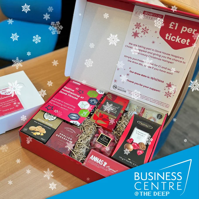 Close up of the Christmas hamper that participants can be in with the chance of winning. The hamper contains bon-bons, hot chocolate, a box of chocolates, mini cheddar cheese bites, peanuts and english breakfast tea.