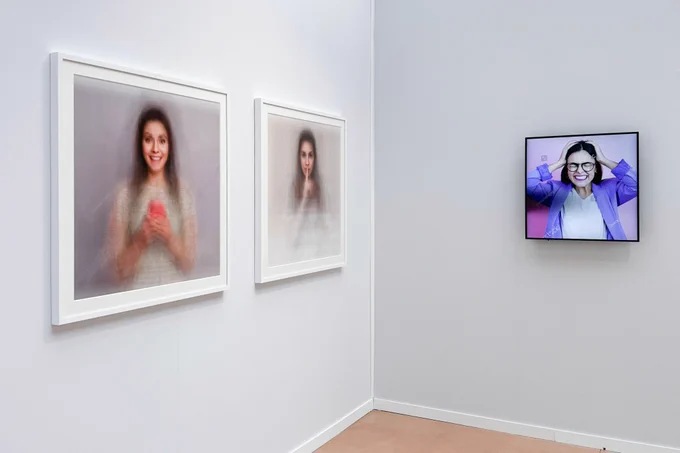 A art fair booth with framed art on the walls
