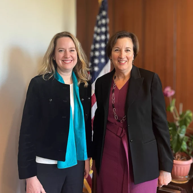 PRM Acting Assistant Secretary Marta Youth stands with IOM Director General Amy Pope.