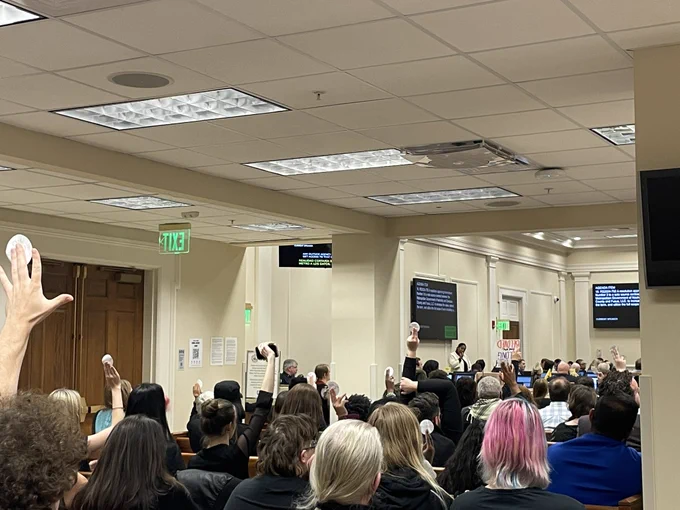 Community members fill the gallery of the Metro Council chambers, many holding up “No FUSUS” stickers to show their solidarity during debate.