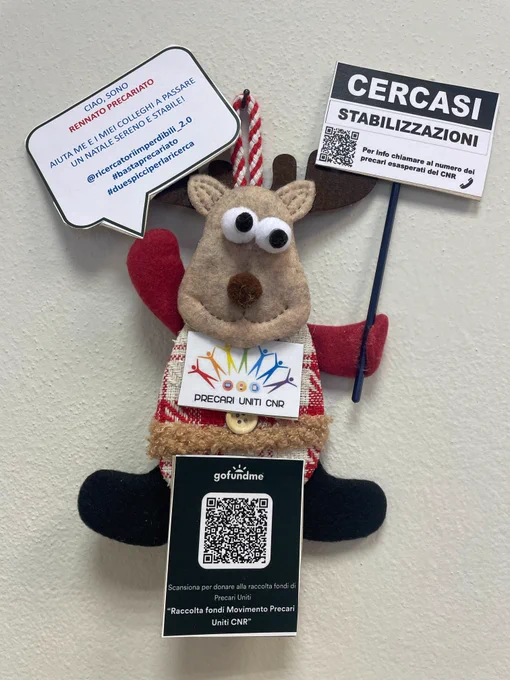 A Xmas tree decoration made of felt. He is called Rennato Precariato, a pun on the italian words for reindeer and non-tenure worker. Rennato Precariato holds placards demonstrating in support of giving tenure to italian researchers with temporary contracts.