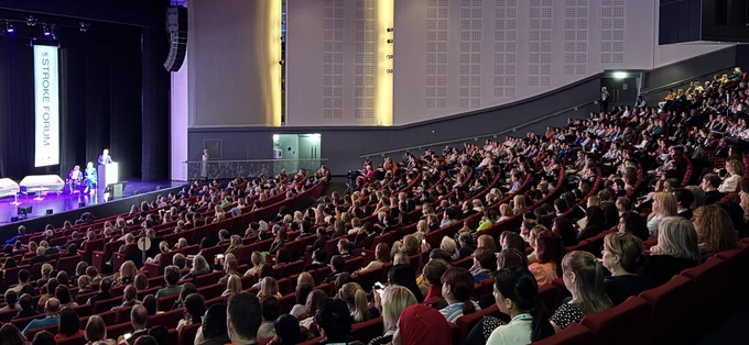 Martin James on stage in front of a large audience.