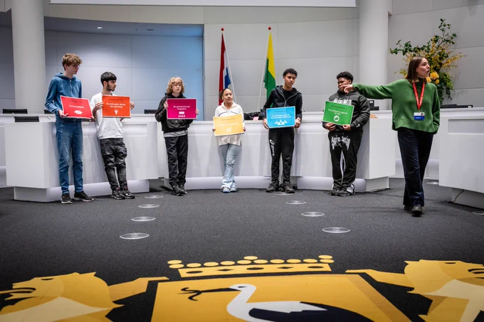 De leerlingen spelen het spel Klassenbezoek@Gemeentehuis in de raadzaal