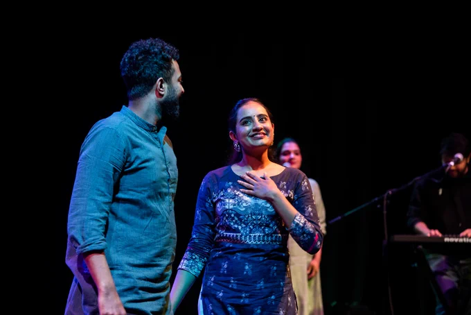 Two performers smiling at the camera. 