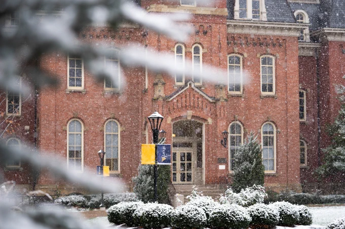 Tight shot of the front of Woodburn Hall as the snow comes down. 