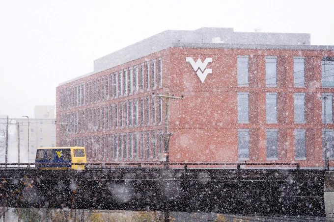 The PRT passes by Reynolds Hall as the snow comes down. 