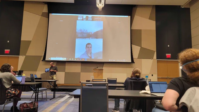 Photo by Richard Zhao of me zooming into the AIIDE 2024 end of conference announcements