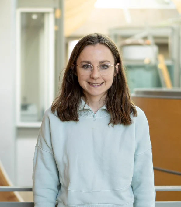 PhD candidate Kate Donald is pictured, smiling, overlooking the Michael Smith Laboratories atrium.