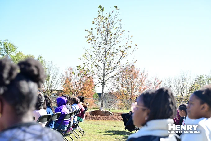 Picture of newly planted tree between students