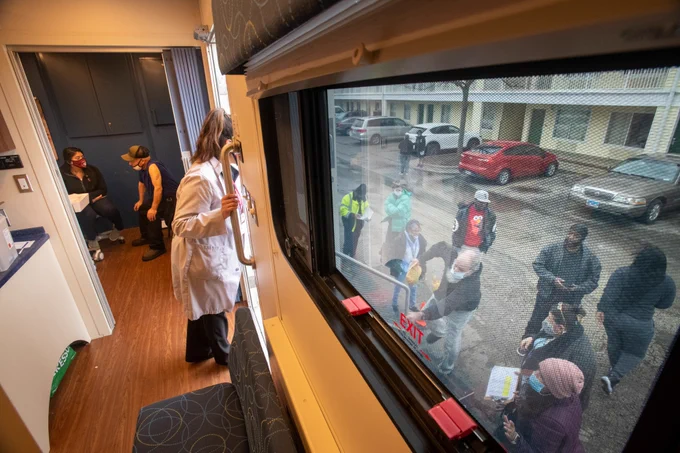 RFU Care Coach team member looks outside the mobile vehicle door to talk to the community. 