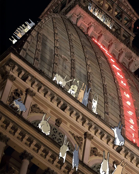 Scorcio fotografico di un monumento su cui sono illuminati i primi numeri della sequenza di Fibonacci: dal basso verso l'alto si legge 1, 1, 2, 3, 5, 8, 13, 21, 34, etc. Intorno vi sono disegnati dei coniglietti. L'illustrazione è di Claudia Flandoli ed è presa da "The Fibonacci Issue", l'albo a fumetti di Comics&Science.