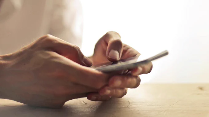 Hands typing on a smartphone 
