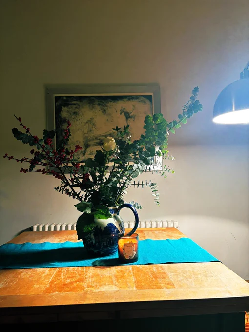 Jug with eucalyptus, berries, white rose & candle