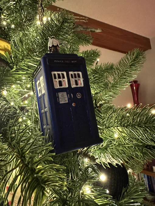 Tardis / Police Box ornament nestled on a lit Christmas tree.