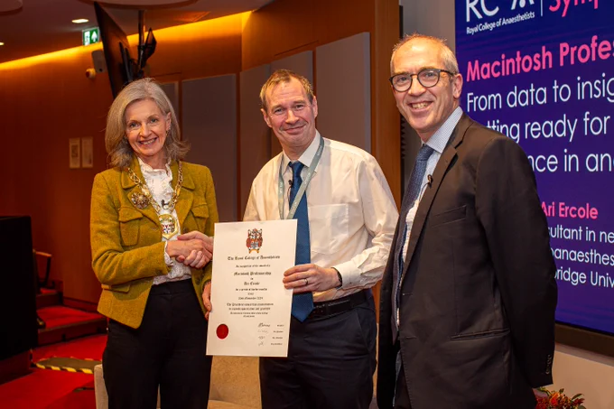 Dr Ari Ercole holding a certificate for the Macintosh Lecture with President Dr Claire Shannon and Professor Iain Moppett.
