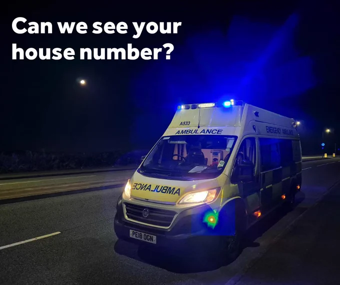 An ambulance parked on a road at night under a full moon, with emergency lights activated. Text overlay asks, "Can we see your house number
