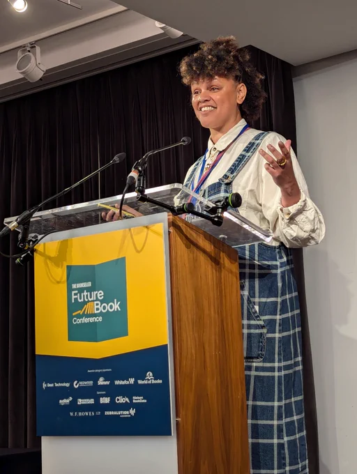 Gemma Cairne on stage at FutureBook stood behind a lectern speaking into a microphone.