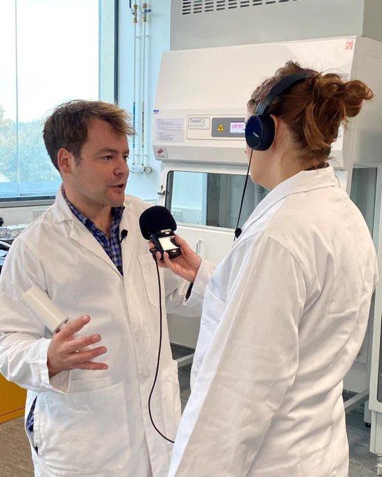 Richard Cross (left) speaking with Alice Hope (right) in a laboratory, recording a podcast episode