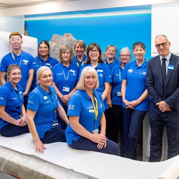 The Leeds Lung Health Check team standing together and smiling on the mobile screening unit.