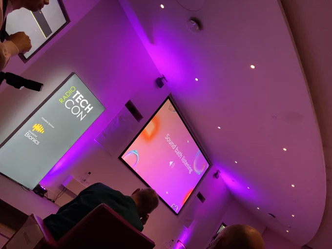 Dimmed lighting and an empty stage while the audience listens.