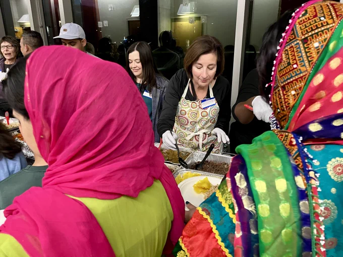 PRM Acting Assistant Secretary Marta Youth serves food at ECDC's Refugees' First Thanksgiving.