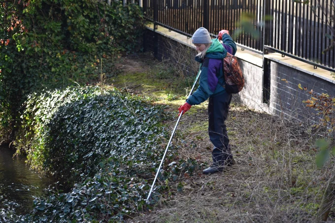 Photo of a person litter picking on the riverbank