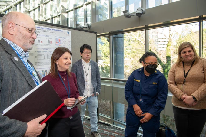 CDC Director Dr. Mandy Cohen looks at a poster presentation with CDC staff