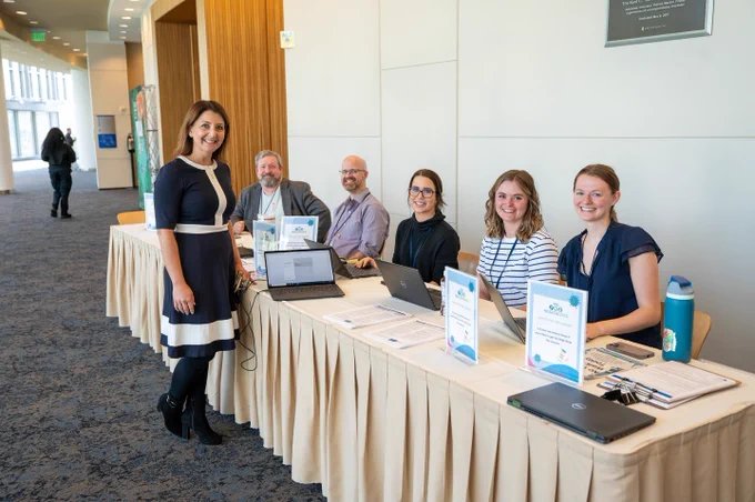 CDC Director Dr. Mandy Cohen stands with CDC staff at a registration table
