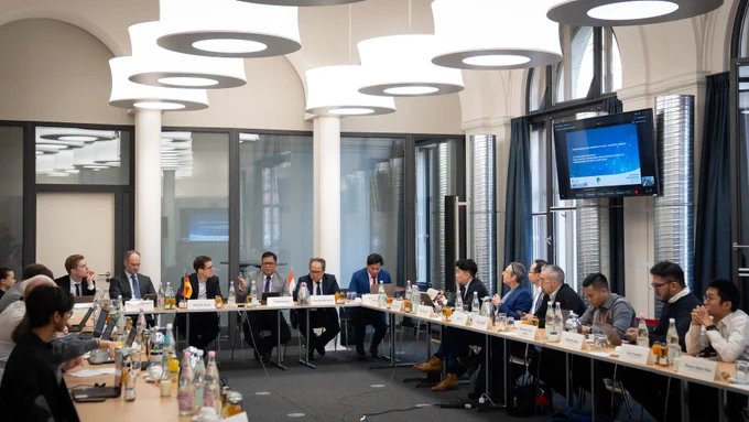 Foto von der zweiten Jahressitzung des deutsch-indonesischen Digitaldialogs, die Teilnehmenden sitzen an einem U-förmigen Tisch und unterhalten sich. 