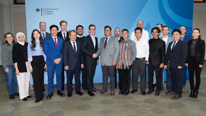 Gruppenfoto der Teilnehmerinnen und Teilnehmer der zweiten Jahressitzung des deutsch-indonesischen Digitaldialogs. In der Mitte stehen Ben Brake und Ichwan Nasution, sie schütteln sich die Hände und lächeln in die Kamera. 