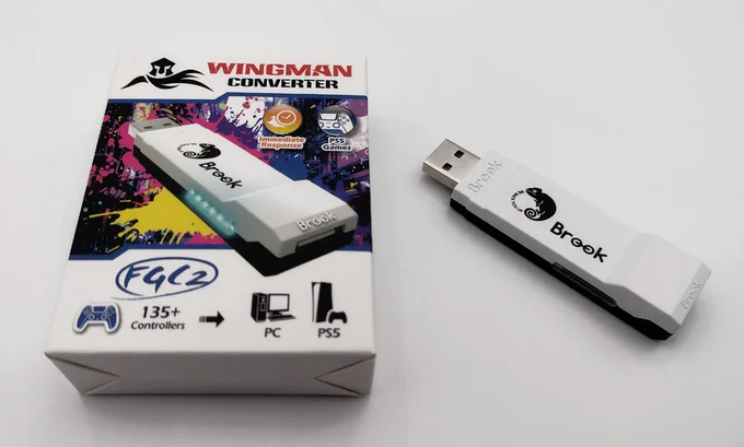 White and black USB stick dongle, with Brook text and Cameleon logo. Box states 135  controller to PC or PS5.