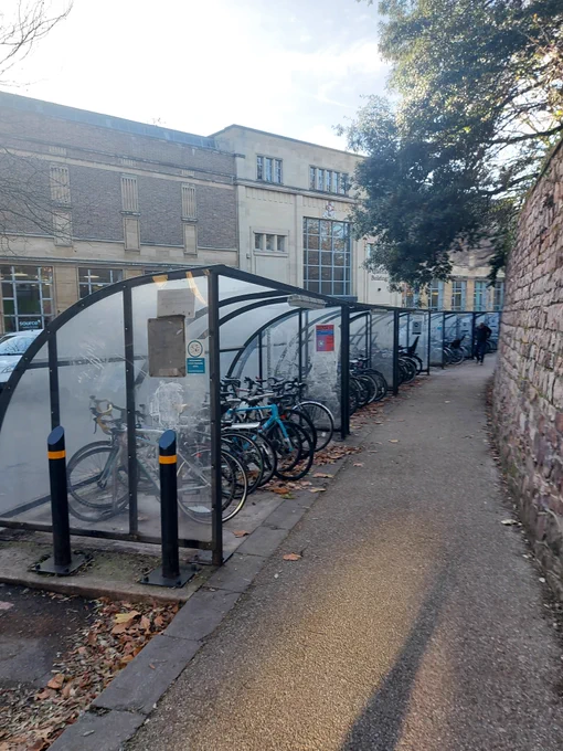 A row of sheds for bicycles, in front of the Queen's Building in University of Bristol