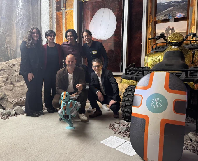 The team poses around a dog robot and a prototype of the system.