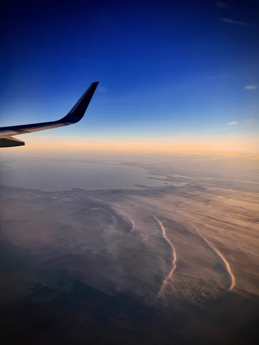 View of Lake Okeechobee from a plane at sunrise, with shallow low level clouds or fog with waves embedded in them. 