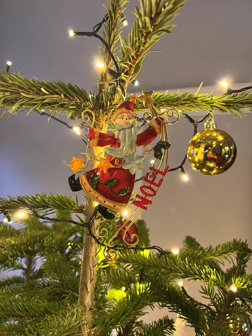 a close up of a father christmas decoration on the christmas tree