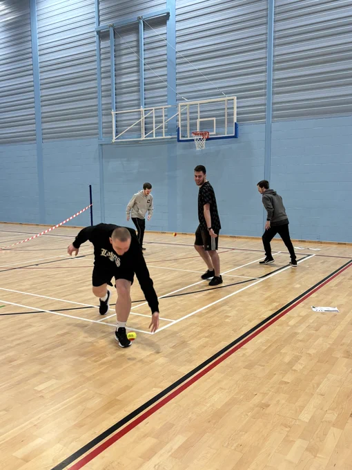 2 pairs of students playing the game hot potato on a tennis court. 