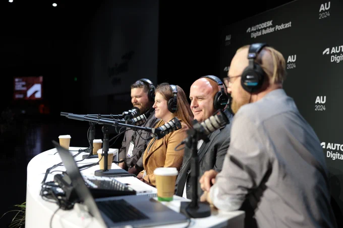 Five panelists participating in the Autodesk Digital Builder Podcast at AU 2024, seated at a table with microphones in front of a large audience.